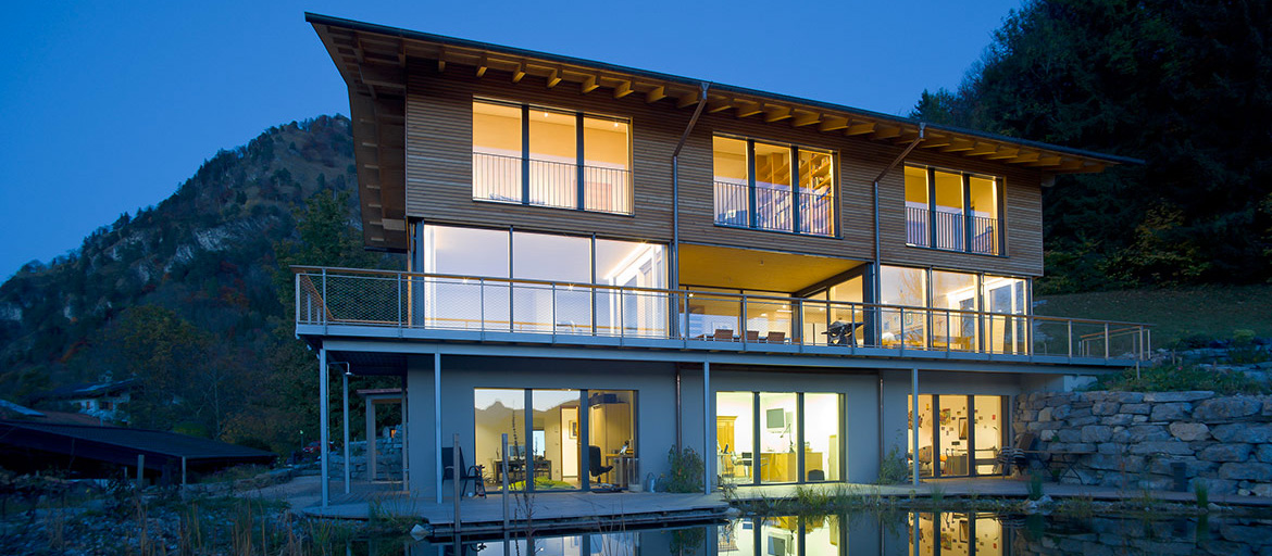 Beleutetes Passivhaus in der Dämmerung